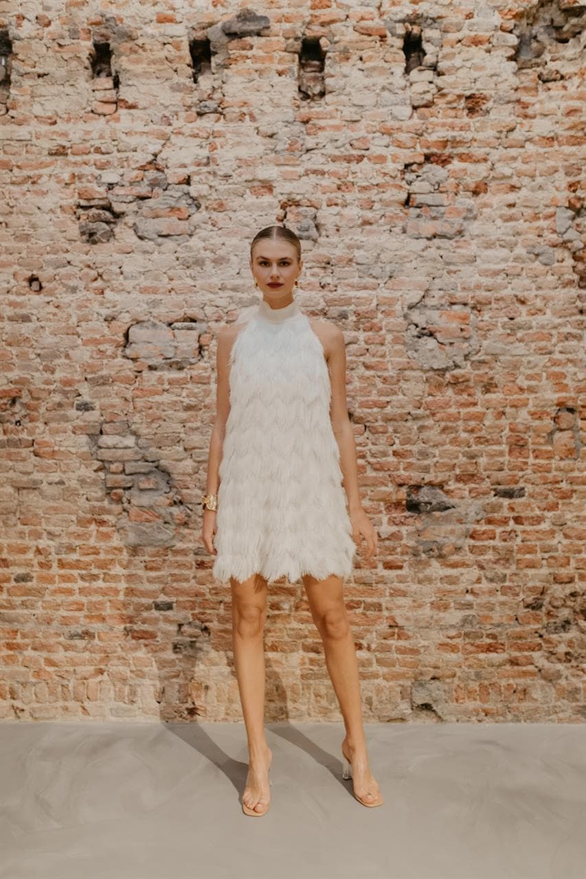 bruid met korte trouwjurk met franjes en halter voor tweede look op de bruiloft