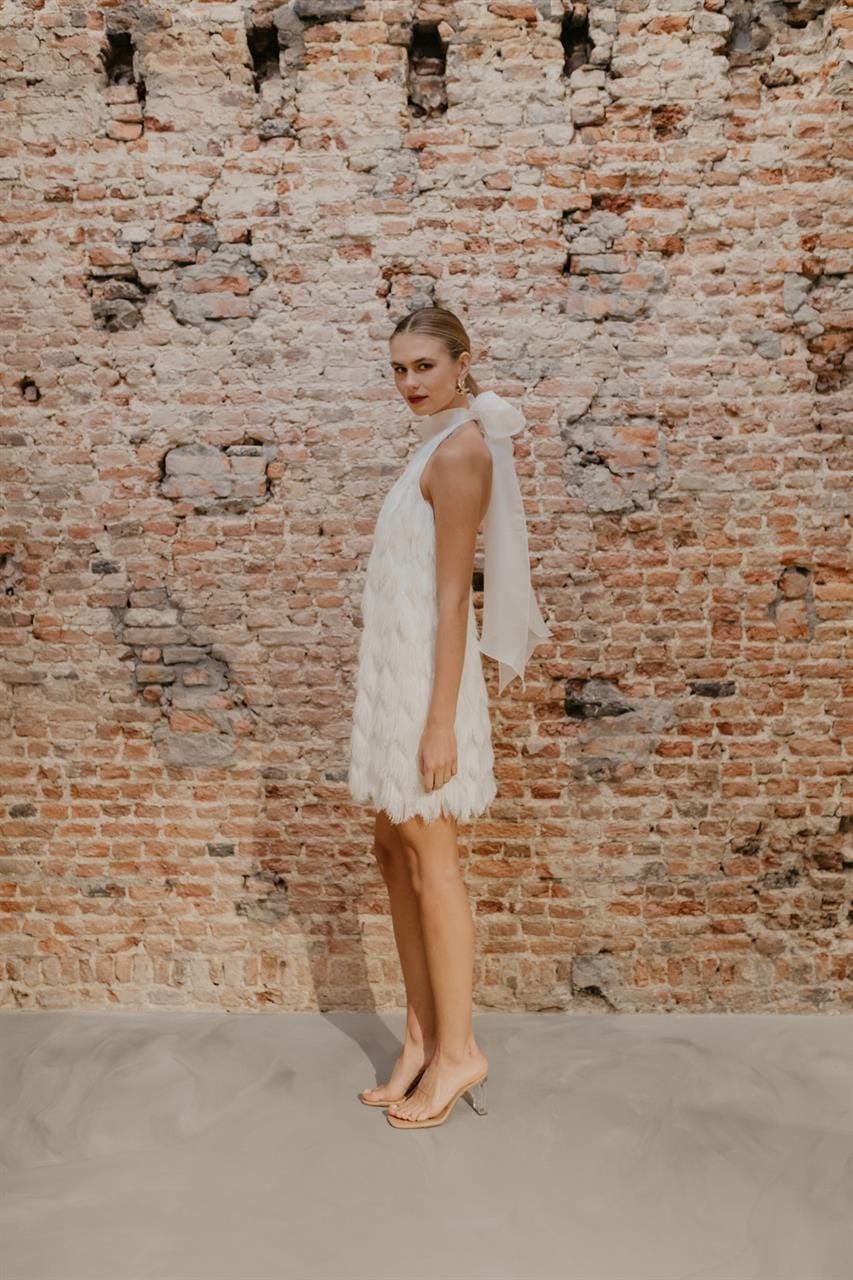 bruid met korte trouwjurk met franjes en halter voor tweede look op de bruiloft